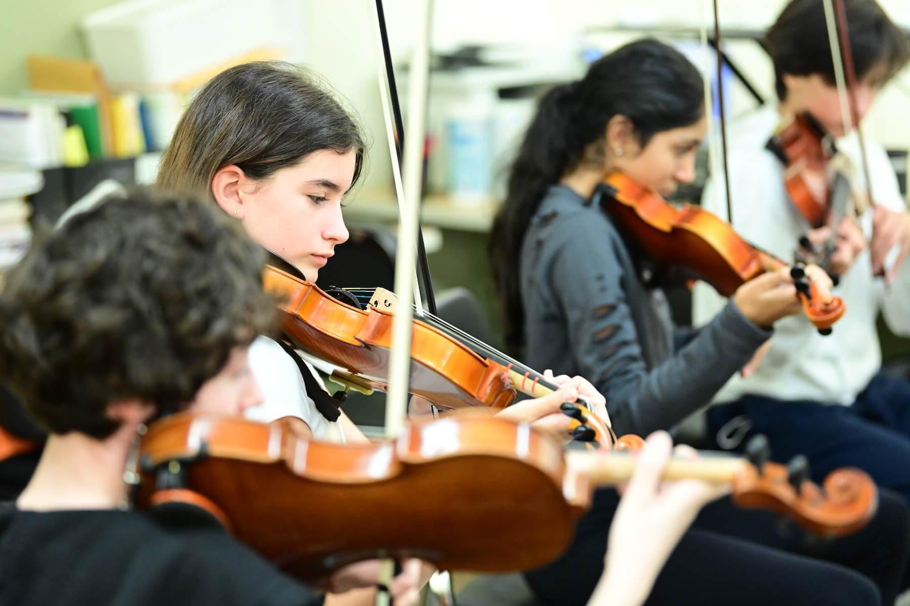 Ethical Culture Fieldston School students practicing on violins in strings class