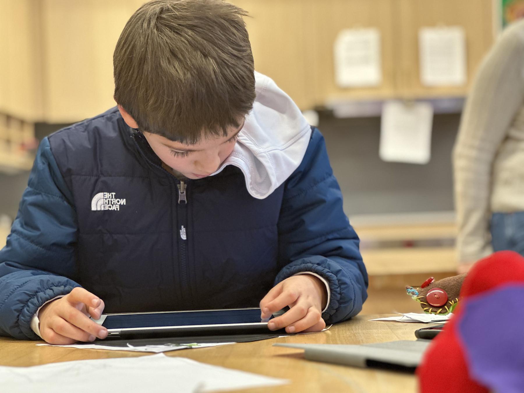 Fieldston Lower student works on his iPad in classroom.