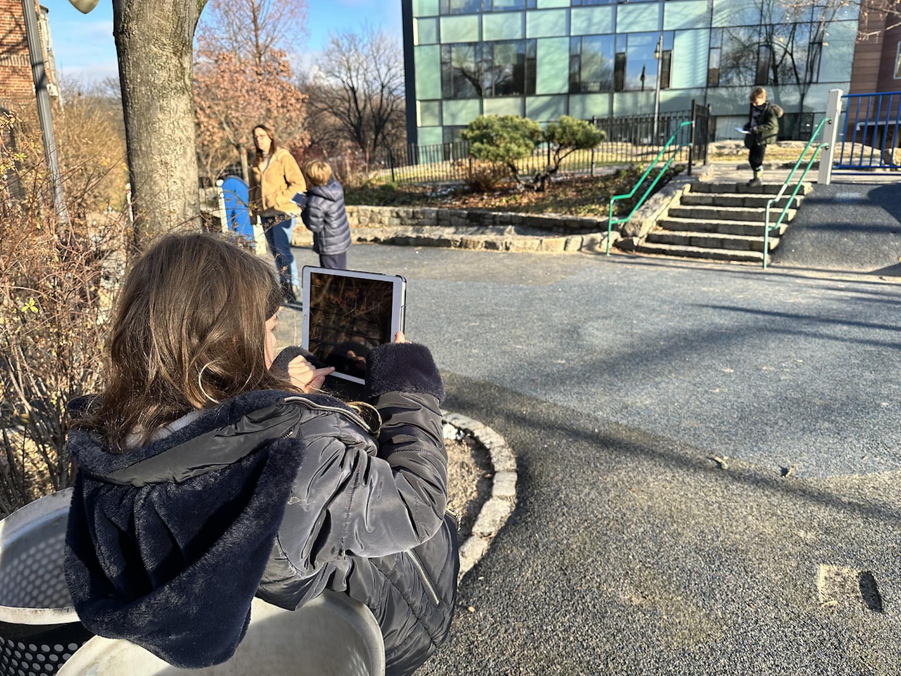 Student takes photo of playground outside using iPad at Fieldston Lower.